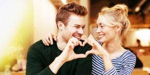 man and woman making a heart together with their hands