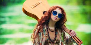 Woman in blue shades with guitar outdoors