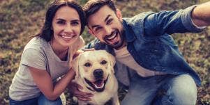 couple posing for a selfie with dog