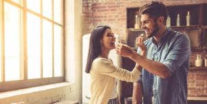 man and woman eating together in kitchen