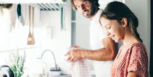 Father and young teen daughter in kitchen 
