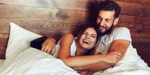 man and woman cuddling in bed