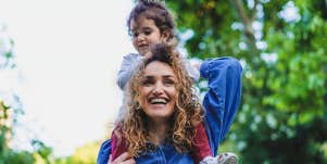 mom carrying daughter on shoulders