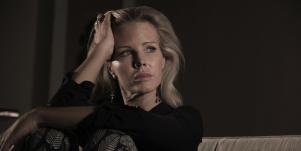 woman with head in her hands looking away
