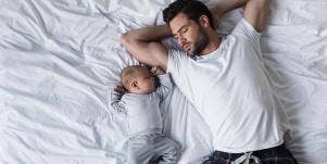 man with baby on bed