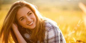Content woman smiles in wheat field