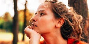 Sad woman outdoors stares into distance