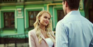 Woman with sardonic smile talks to man