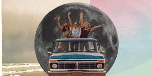 three girls in an old school truck in front of the moon