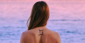 woman with gemini tattoo on back