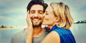 blonde wife kisses husband's cheek while he smiles