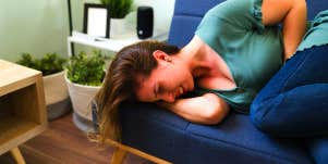 woman with stomach pain laying on couch