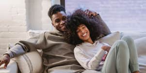 Couple cuddling and smiling on couch