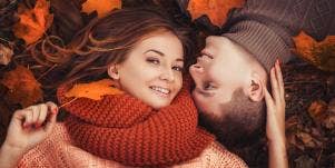 man and woman lying on top of Fall leaves