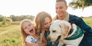 woman cuddling with dog and family