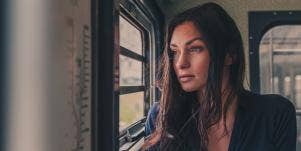 upset woman looking out a window