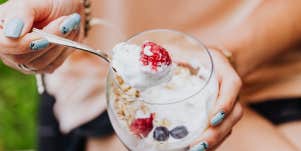 Woman eating yogurt with fruit 