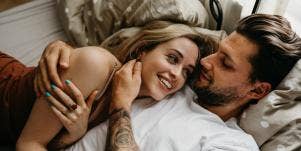 man and woman cuddling in bed
