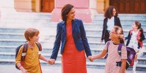 mom holding the hands of two children