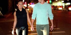 young attractive couple holding hands across street