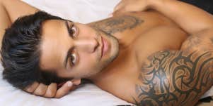 man with tattoos on bed