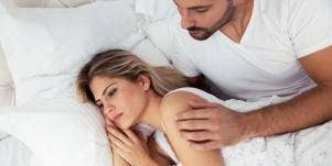 unhappy woman laying in bed with husband