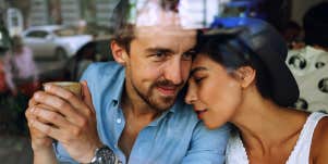 man and woman cuddling in a restaurant, taken through the glass