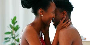 woman kissing man in bed