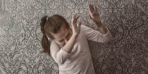 girl in protective position, afraid of being hurt