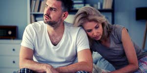 unhappy couple sitting on bed in pajamas upset about their sexless marriage
