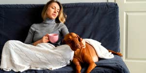 sad woman sitting on the couch with her dog