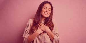 woman holding her palms against her heart