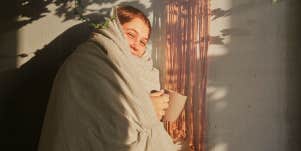 Woman snuggling in a comfortable blanket