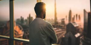 man looking out window 