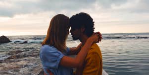 man and woman hugging on beach