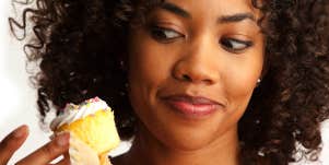 woman tempted to eat cupcake