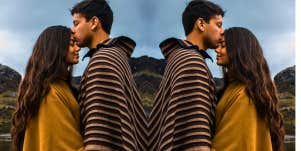 empathetic couple standing together with the man kissing the woman's head