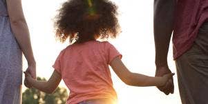 parents holding daughter's hand