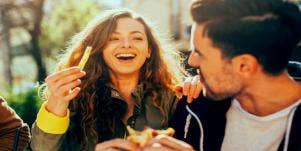 man and woman eating and flirting