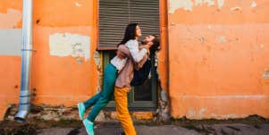 man embracing woman tightly and sweeping her off her fight