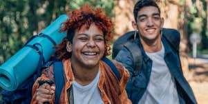 A happy traveling couple run toward the camera 