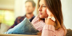 unhappy couple sitting on the couch at home after a fight