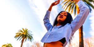 woman posing under palm trees