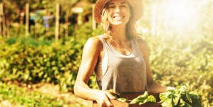 Smiling woman with produce harvest from garden