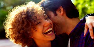 woman smiling while she hugs her boyfriend