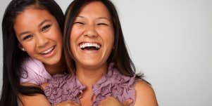 A fun loving mother and daughter share a happy moment with big smiles on their faces