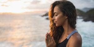 woman meditating on beach
