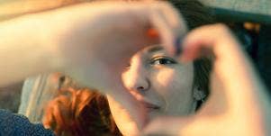 happy woman making heart shape with hands