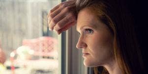 woman looking out the window thinking about negative feedback