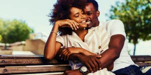 happy couple sitting on a bench hugging